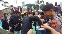 Aksi Simpatik, Polisi Bagikan Air Mineral dan Roti kepada Buruh di Depan DPR/MPR